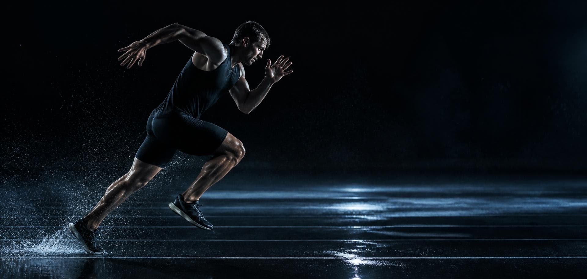 Sprinter accelerating on a wet track at night